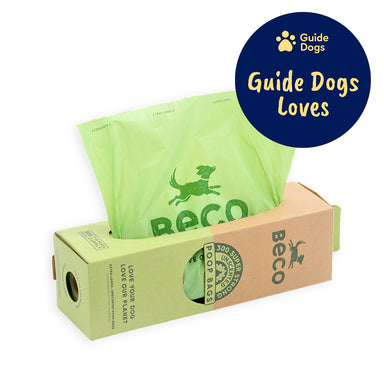 A close up of a cardboard box dispensing poo bags. The Guide Dogs Loves logo is in the top right.