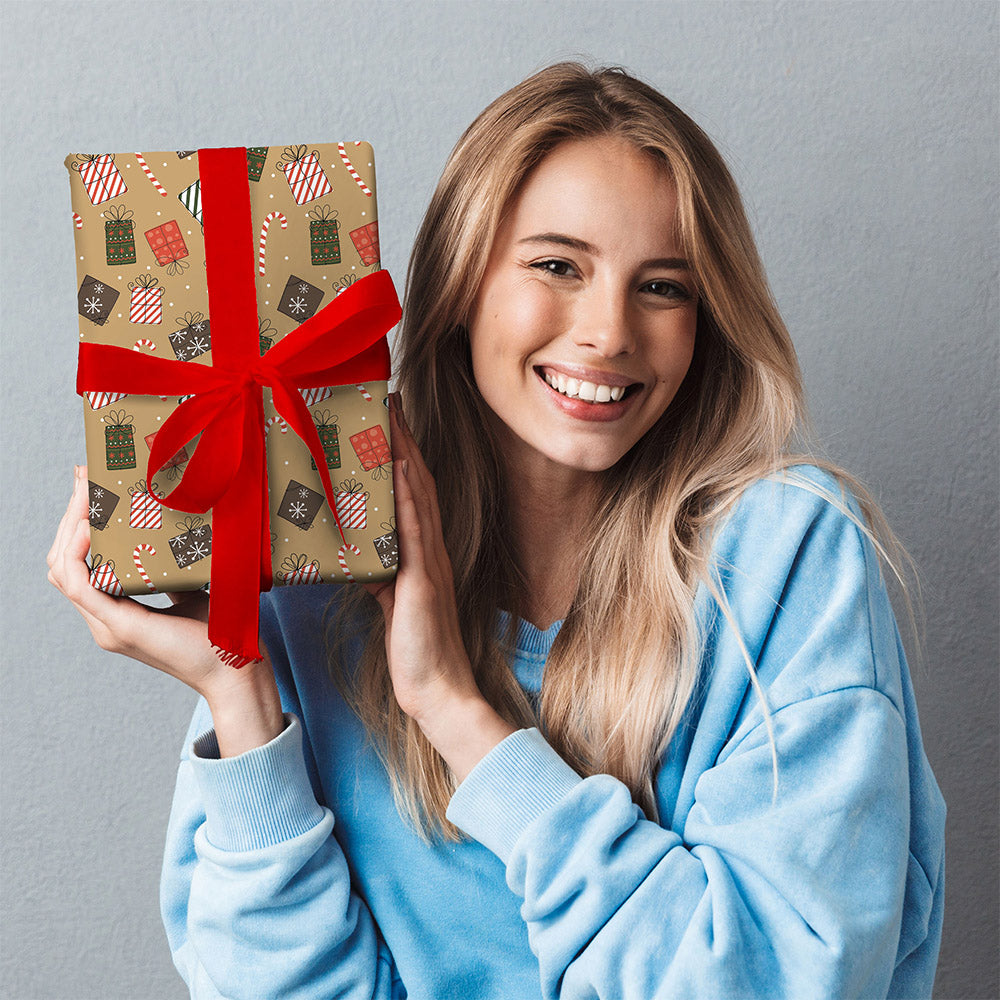 A woman holding a wrapped present. The wrap is brown with illustrations of candy canes and festive presents.