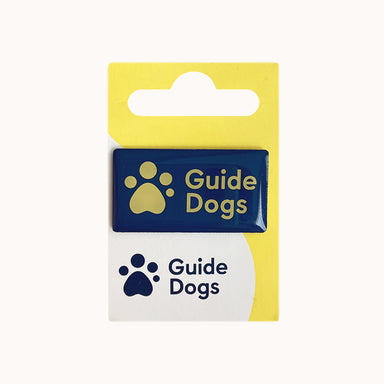 Guide Dogs logo pin badge on a backing card featuring the same logo.