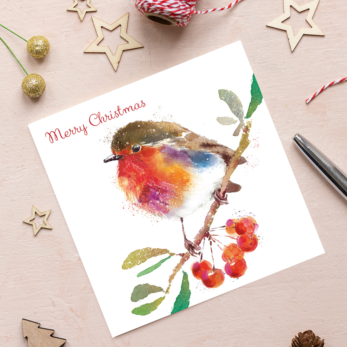 An illustration of a watercolour robin sat on a branch with berries underneath against a white background. The words ‘Merry Christmas’ appear above the robin, in the top left corner in red.