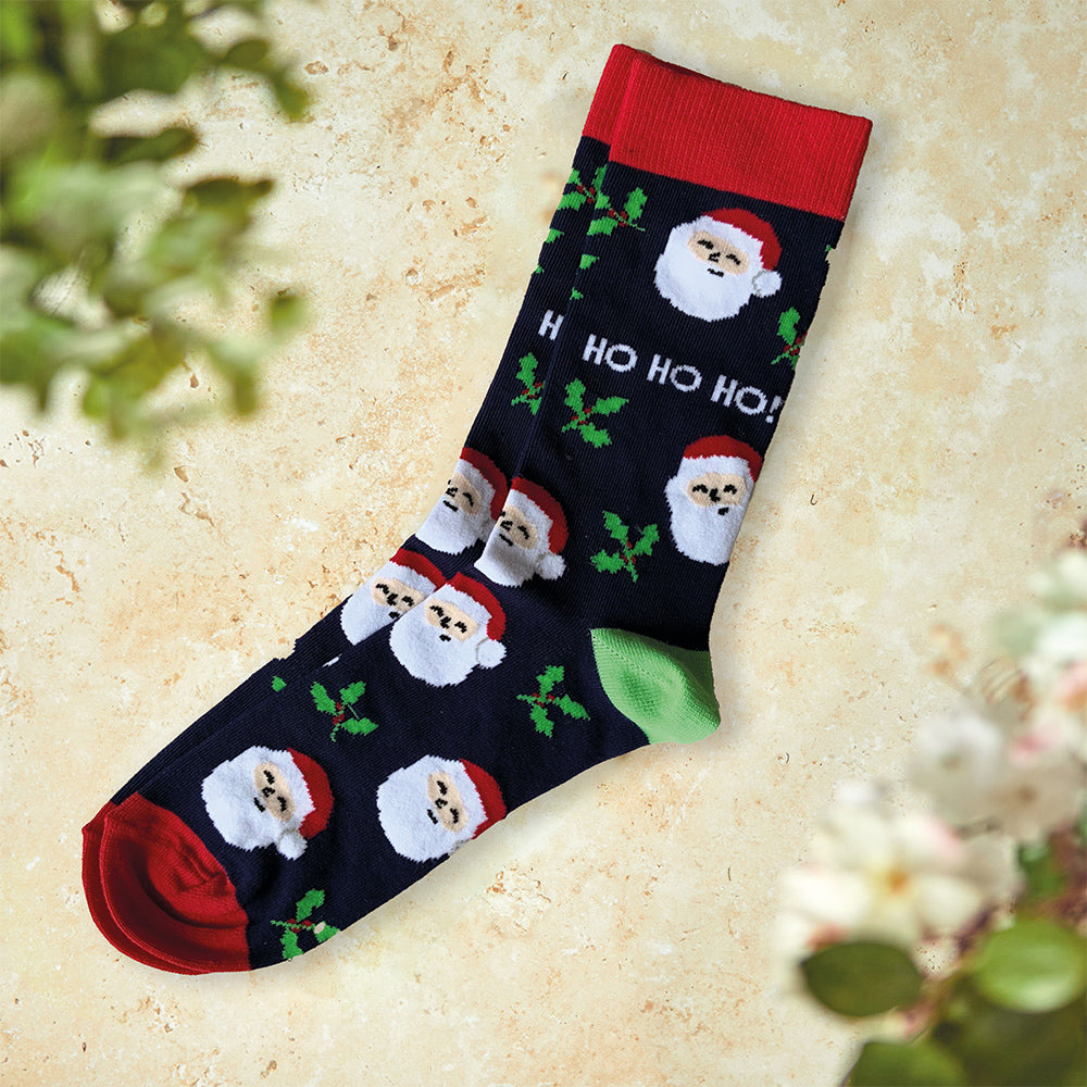 A pair of socks with laughing Santas and holly, red trim and green heel