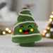 A Christmas tree shaped squeaky dog toy with a smiley face.