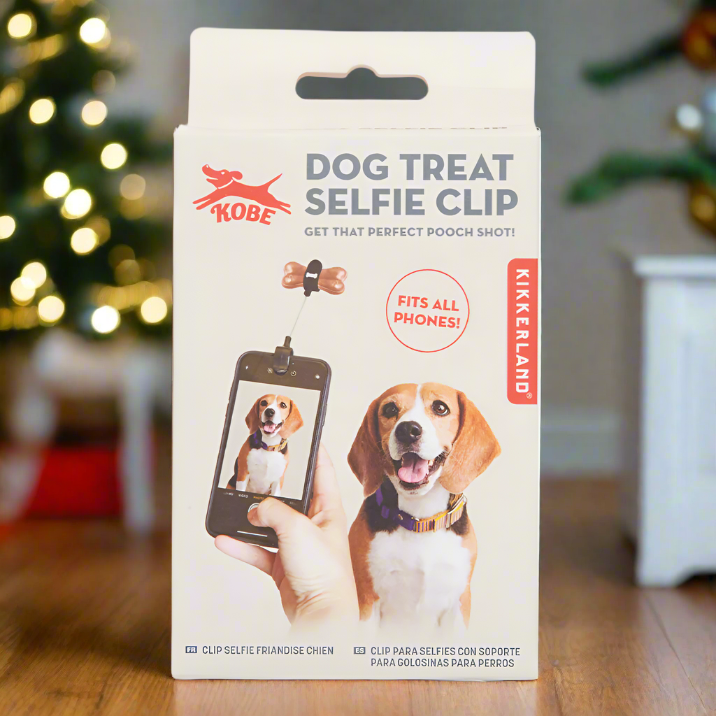 The product box for a dog treat selfie clip featuring a photograph of a dog having their picture taken with the help of a treat attached to a phone.