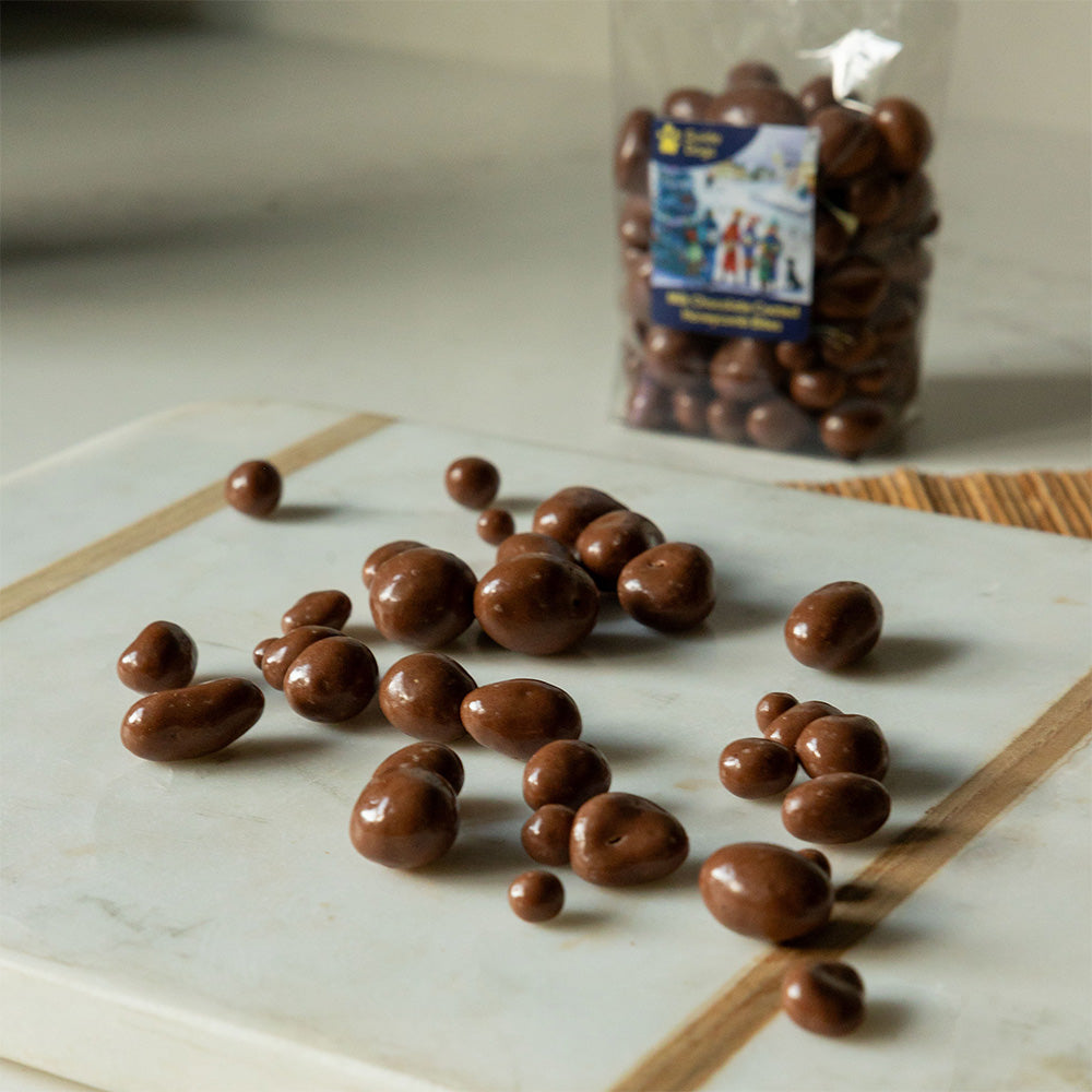 A photograph of a selection of mini chocolate honeycomb bites. The clear bag packaging can be seen in the background.