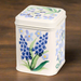 A cream tin with Emma Bridgwater flower illustration. The tin is on a wooden background.