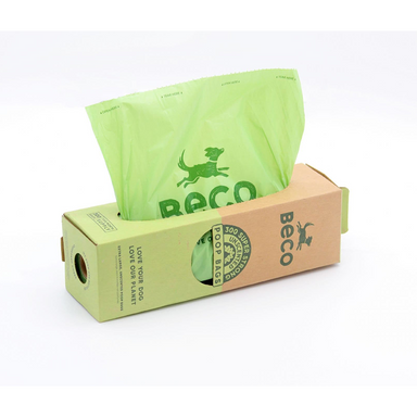 A close up of a cardboard box dispensing poo bags. 