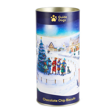 A close-up of the Guide Dogs Christmas Eve Village - Chocolate Chip Biscuits. A village celebrating Christmas is used as packaging wrap around the cylindrical biscuit tin.
