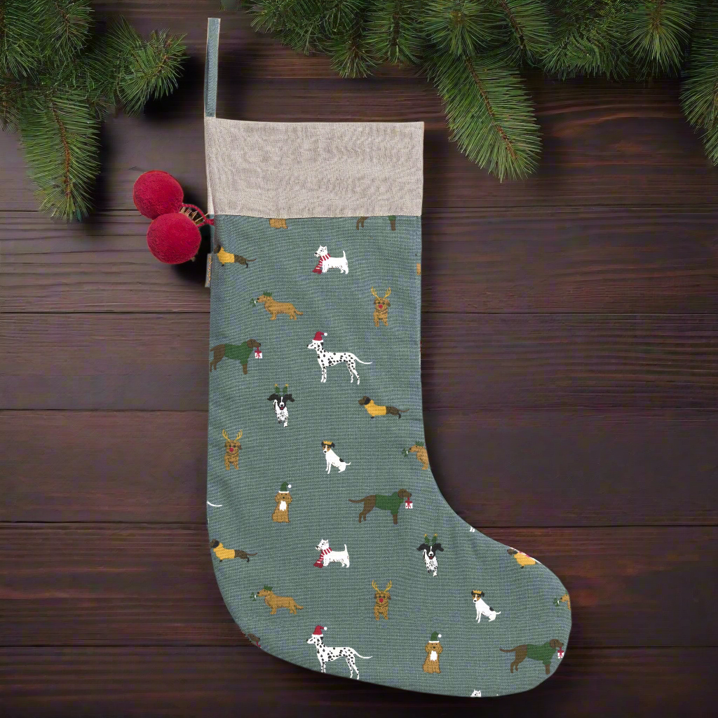 A teal blue stocking with overall pattern of dogs wearing Christmas hats and scarves.  The stocking has two red pompoms and a hanging loop.