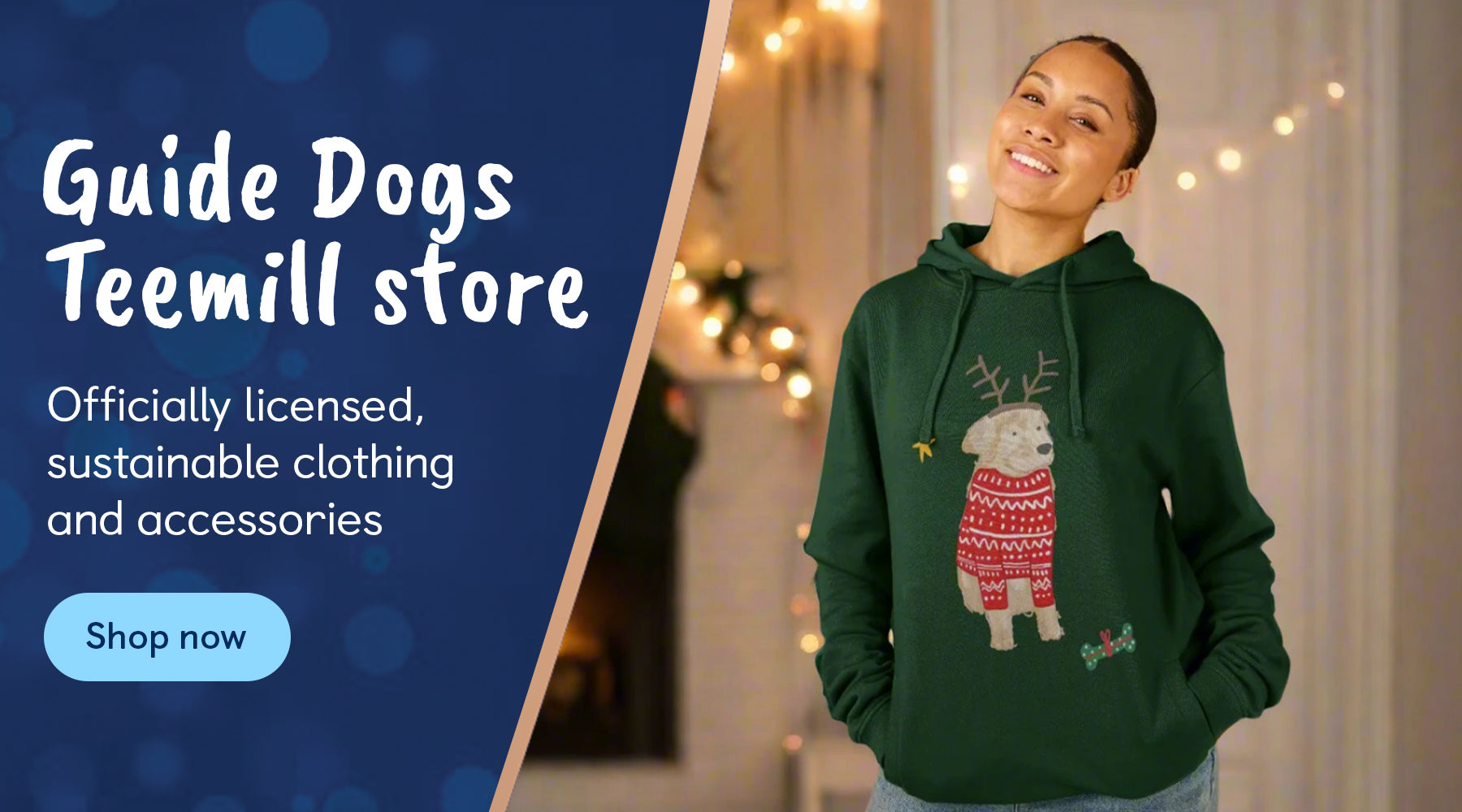 A woman is wearing a dark green hoodie featuring an illustration of a Yellow Labrador wearing antlers and a red Christmas jumper. There is an ask to shop at the Guide Dogs Teemill store where you can buy officially licensed, sustainable clothing and accessories.