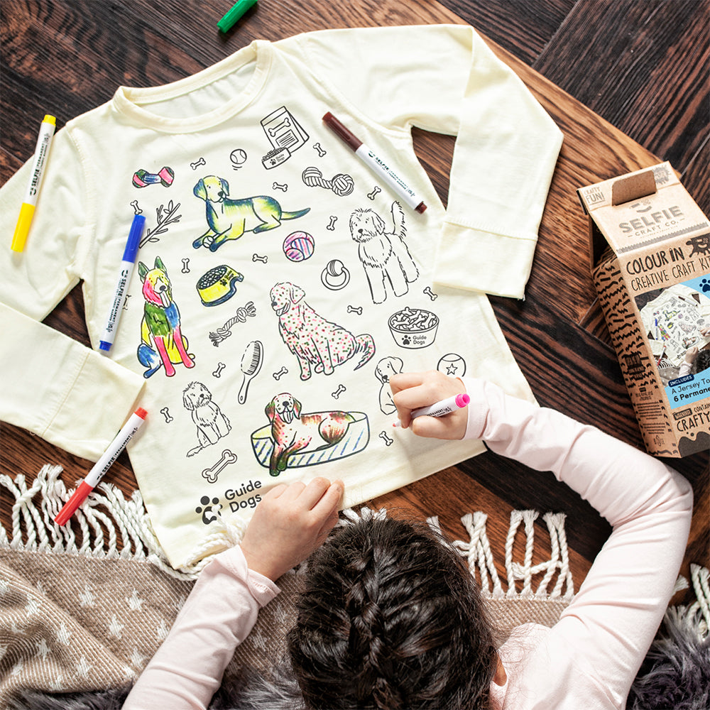 A child colours in their Guide Dogs Colour In T-shirt.