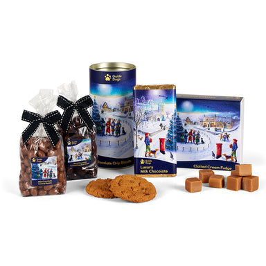 An image of the entire Guide Dogs Christmas Eve Village collection, featuring the Milk Chocolate Coated Raisins, Dark Chocolate Coated Candied Ginger, Chocolate Chip Biscuits, Luxury Milk Chocolate and Clotted Cream Fudge. (Images described from left to right)