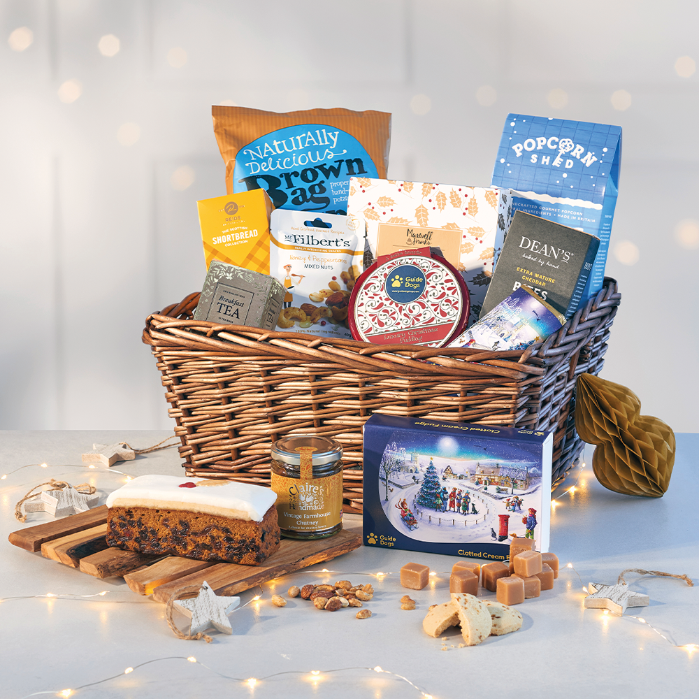A close up shot of the Guide Dogs Indulgent Christmas Hamper. All of the hampers contents are on display and are being stored in a basket.