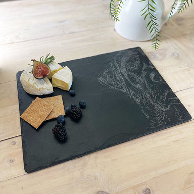 Slate cheeseboard with etched Labrador face is shown with crackers and cheese.