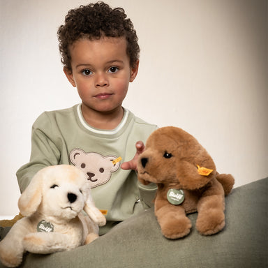 A child plays with his Lenny Labrador Puppy toy.