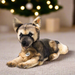 A close-up of the Mike German Shepherd soft toy. The toy is on a carpet with a Christmas tree in the background.