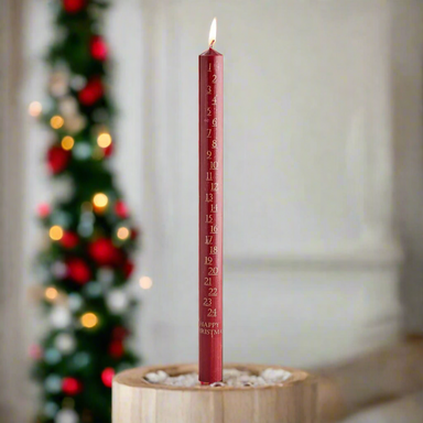 A single red candle marked with the December days in gold and the greeting Happy Christmas at the bottom.