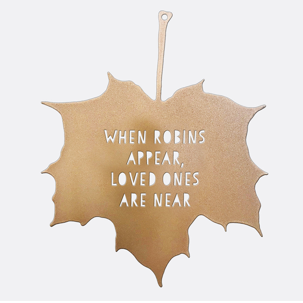 A closeup of the Decorative Garden Leaf. A metal leaf ornament with the lettering 'When Robins Appear, Loved Ones Are Near' is set against a white background.