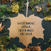 A closeup of the Decorative Garden Leaf. A metal leaf ornament with the lettering 'When Robins Appear, Loved Ones Are Near' is set against a festive background.