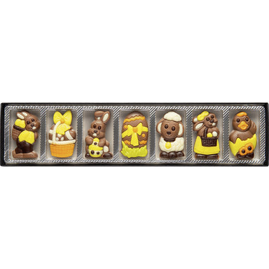 Seven Easter themed chocolates featuring bunnies, eggs, an Easter basket, a duckling and a lamb. The chocolates are in a row in their packaging.