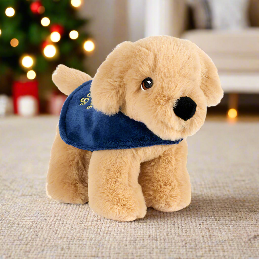 A small golden retriever soft toy wearing a blue Guide Dogs coat.