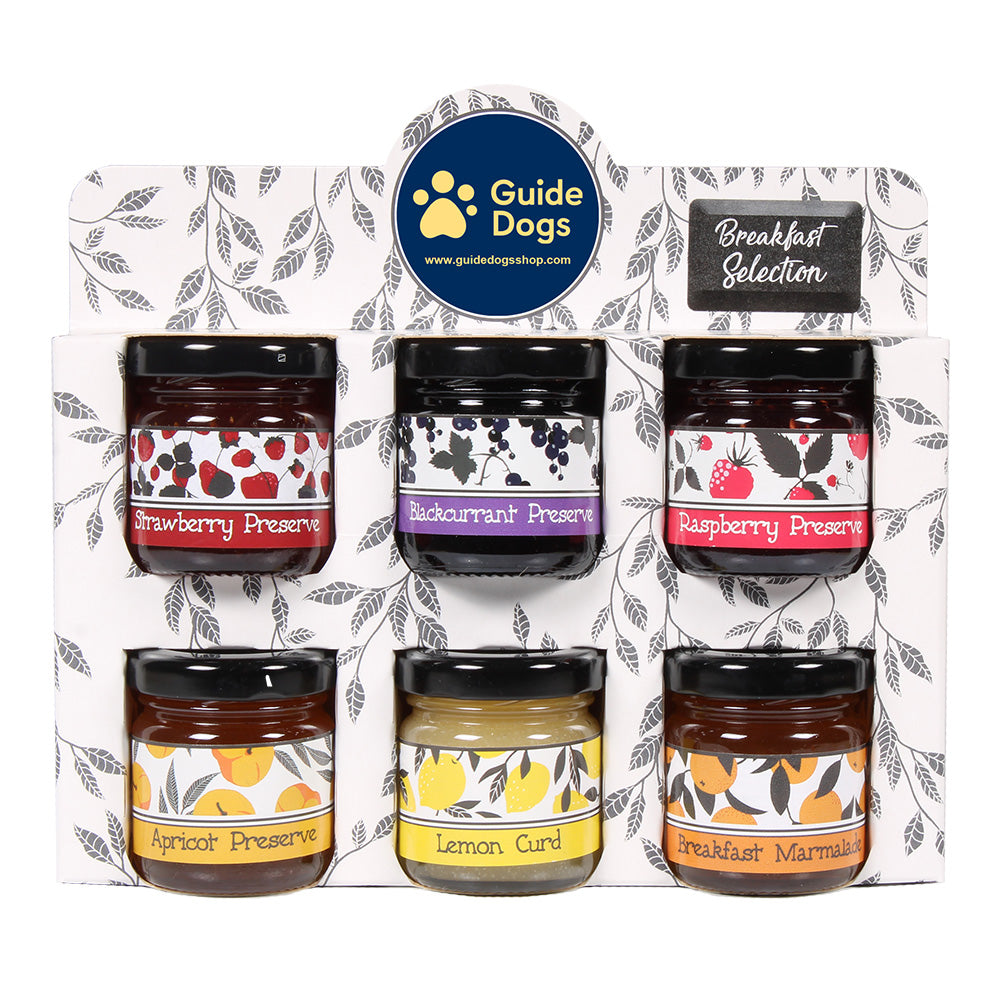 A Guide Dogs branded container featuring six sweet preserves in small jars with the text 'Breakfast Selection' at the top right corner.