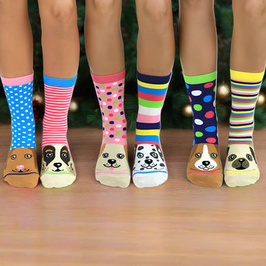 Pictures of three pairs of legs and feet, all with different sock designs on. A Christmas tree appears behind them.