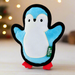 A plush dog toy in the shape of a penguin, in bright blue, white and with black piping all around the edge. The Beco logo is on a seam label and the penguin has small red feet.