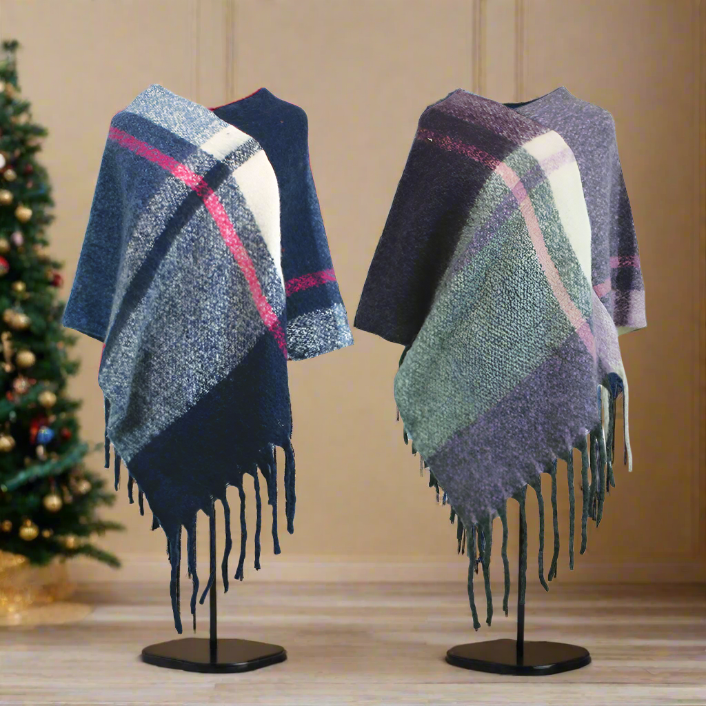 Two checked poncho, one shades of blue and pink, the other shades of green and purple made from a wool-feel material. They are on mannequins with a Christmas tree in the background.