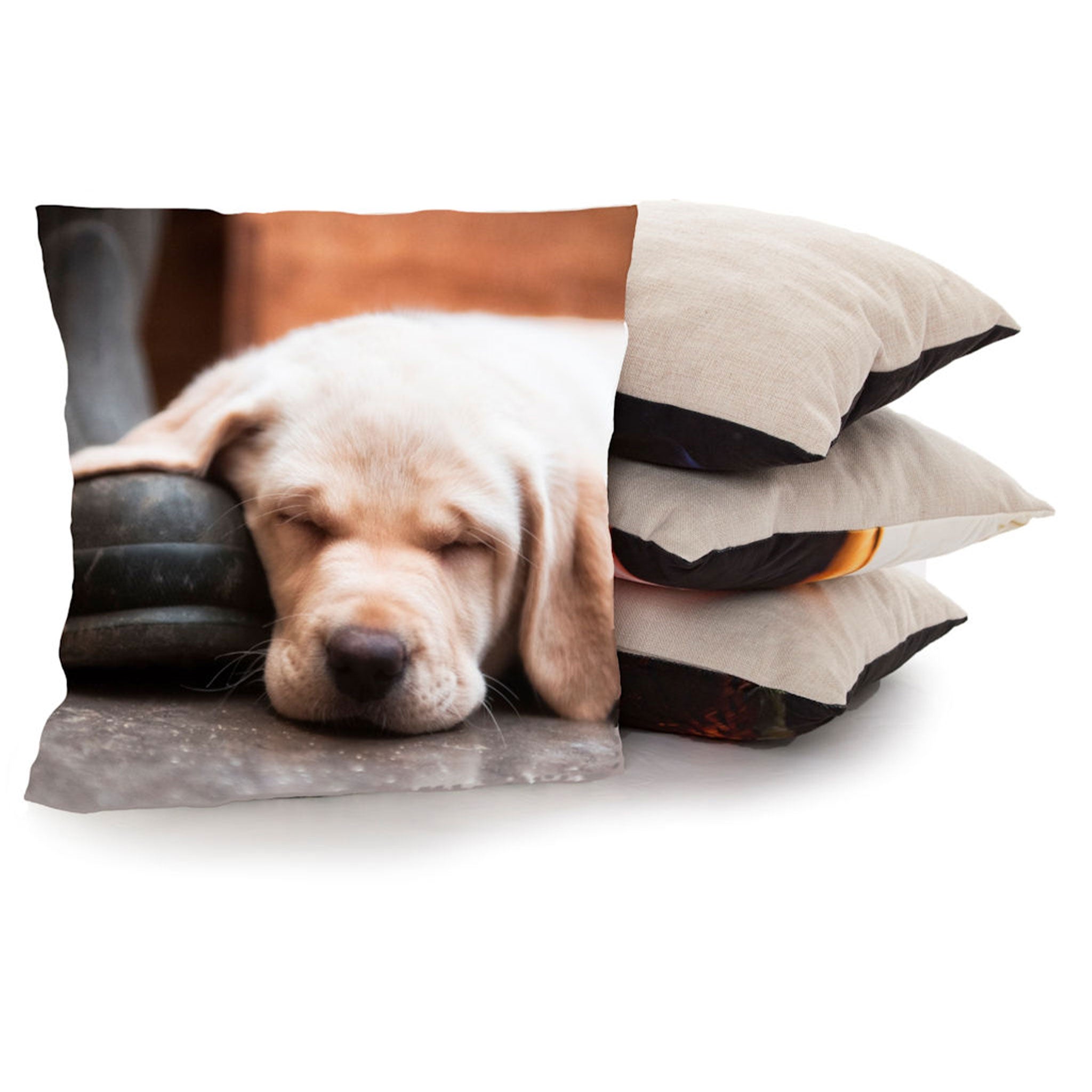 A cushion with an image of a sleeping Labrador Puppy is propped up against a stack of three cushions.