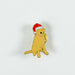 Sitting golden Labrador pin badge. The dog is wearing a red Christmas hat