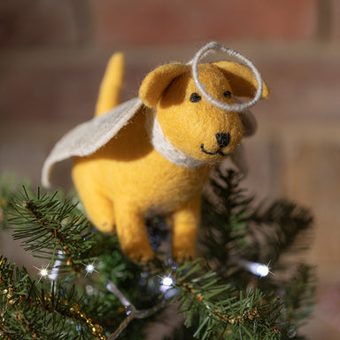 A close-up of a golden Labrador tree topper decoration with silver wings and halo