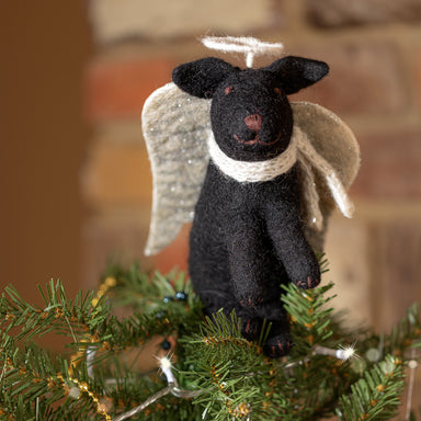 A close up of a black Labrador tree topper decoration with silver wings and halo