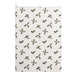 A white teatowel decorated with a repeating pattern of holly and berries.