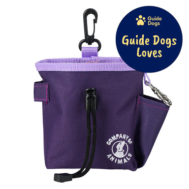A purple treat bag with a black clip and a black draw string. The Company of Animals logo is in white on the bottom right of the treat bag. The Guide Dogs Loves logo is in the top right.