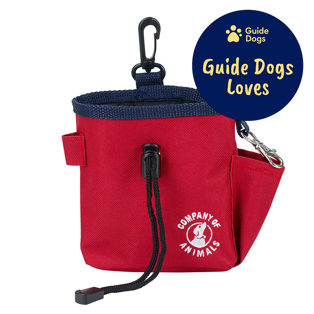 A red treat bag with a black clip and a black draw string. The Company of Animals logo is in white on the bottom right of the treat bag. The Guide Dogs Loves logo is in the top right.