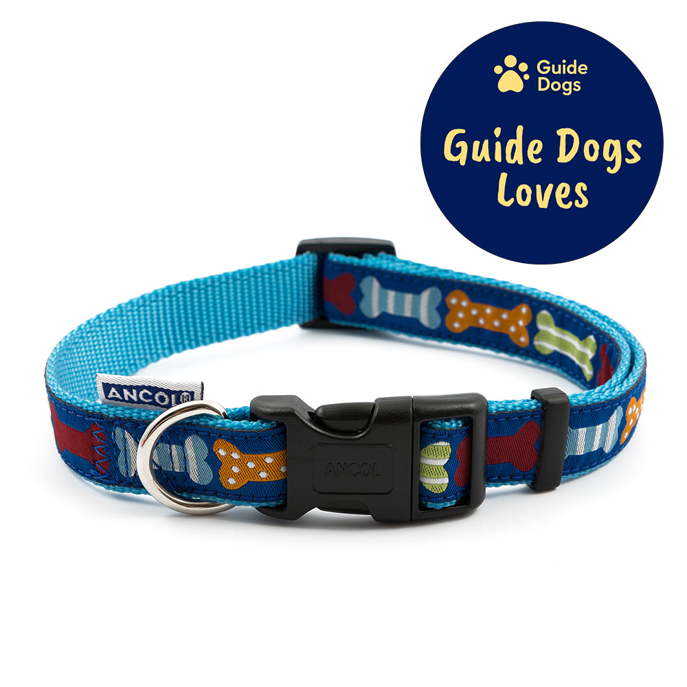 A close up of a blue dog collar by Ancol decorated with different coloured bones. The Guide Dogs Loves logo is in the top right.