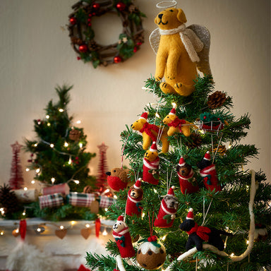 A Christmas tree decorated with felt decorations and a golden Labrador tree topper.