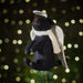 A close up of a Black Labrador christmas tree topper with silver wings and halo.