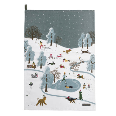 A tea towel with an illustration of a wintry park where people skate, ski and walk their dogs