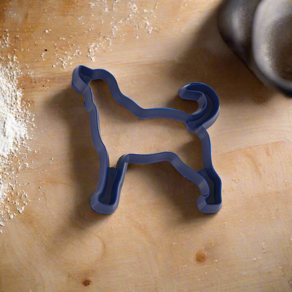 A blue plastic cookie cutter in the shape of a dog.