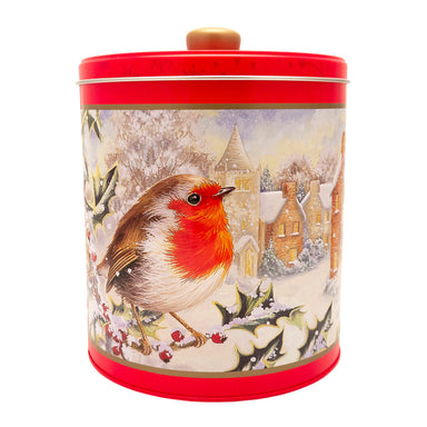 A round biscuit barrel with red lid and base, featuring an illustration of a robin on a holly branch in a snowy village scene. 