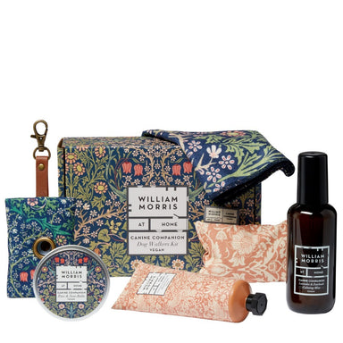 A poo bag with clip holder, tin, cloth, hand cream, hand warmer and spray, next to gift box, all printed in floral William Morris designs