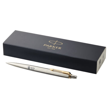 A close up of a black pen box with the Parker logo in gold on the top. In front of the box is the pen, silver with a gold slip and the Guide Dogs logo is on the barrel of the pen.