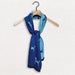 A Guide Dogs branded scarf in two shades of blue hangs on a wooder clothes hanger against a white textured background.