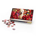 The Guide Dogs Christmas Jigsaw box shows the image on the jigsaw, a Yellow Labrador Puppy surrounded by red baubles and festive lights behind. Some pieces of the puzzle are out of the box, to the left hand side.