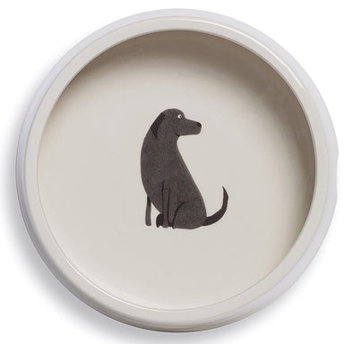A white ceramic dog bowl, decorated with an illustration of a Black Labrador on the bottom of the bowl.