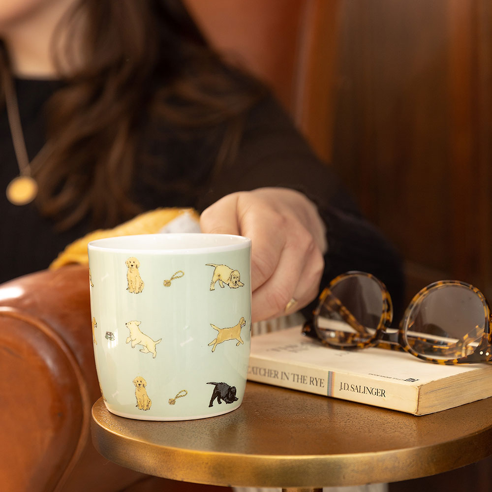 model sits in chair with laura fisher mug with puppy design on a side table