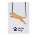 A close up of the leaping dog brass necklace on Guide Dogs branded packaging.
