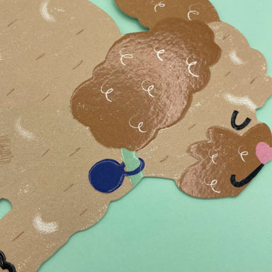 A close up of the cockapoo cut out card on a mint coloured envelope.