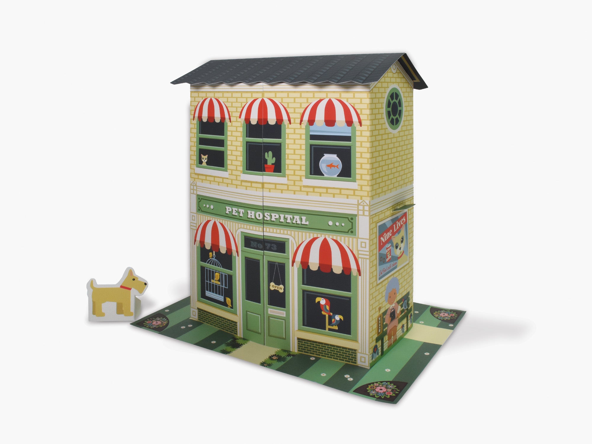 Cardboard pet hospital toy shown fully made up, with cut out dog standing to the side